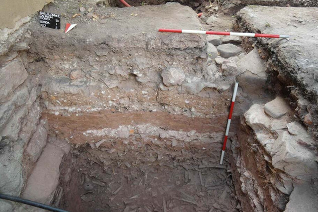 Profil sondy s dochovanými základovými partiemi severní zdi kostela a deponie lidských ostatků, pozůstatků kostnice