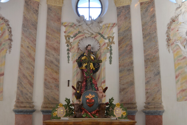 Oltář v kapli, v horní části sousoší Boha Otce, v pozadí socha sv. Isidora