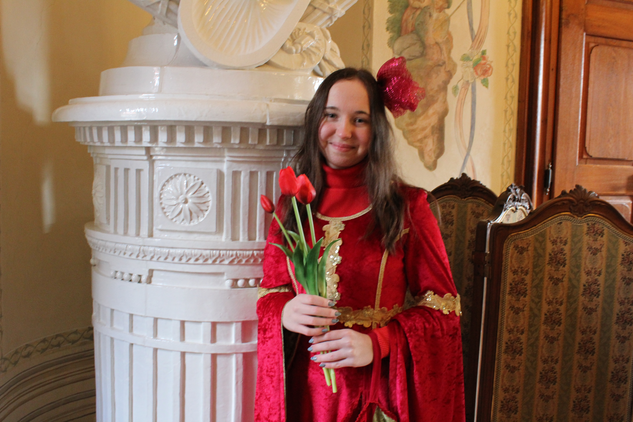 Princezna v červených šatech s kyticí rudých tulipánů