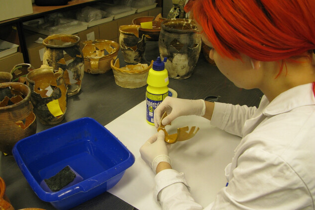 Konzervátorka Doubravka Hajmanová, která na snímku z konzervátorské dílny lepí středověkou keramickou nádobu, začínala v NPÚ v rámci studentské praxe