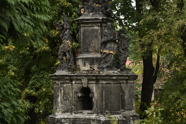 Sloup se sochou Panny Marie a sochami světců v areálu kostela Nalezení sv. Kříže v Liberci, celkový pohled, stav před restaurováním (2018).