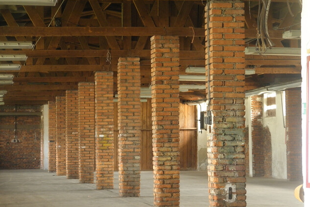 Pohled ve skladové hale v r. 2011 – v době provozu drtírny, by tu návštěvník viděl ocelové barely naplněné uranovou rudou ve čtyřech pěti vrstvách na sobě