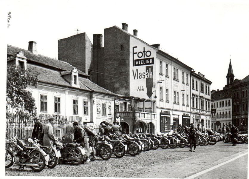 Účastníci motoristické soutěže "Cíl neznámý" z roku 1930 před objektem domu U Ferusů na Senovážném nám. 6. v Českých Budějovicích. Foto: Archiv SOA Třeboň. 