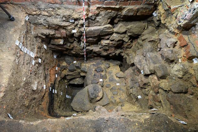 Severozápadní nároží základového zdiva středověkého roubeného domu, zachycené archeologickým výzkumem pod podlahou stávající místnosti 007. Foto Jana Koudelová, NPÚ, ÚOP v Ostravě, 2022.