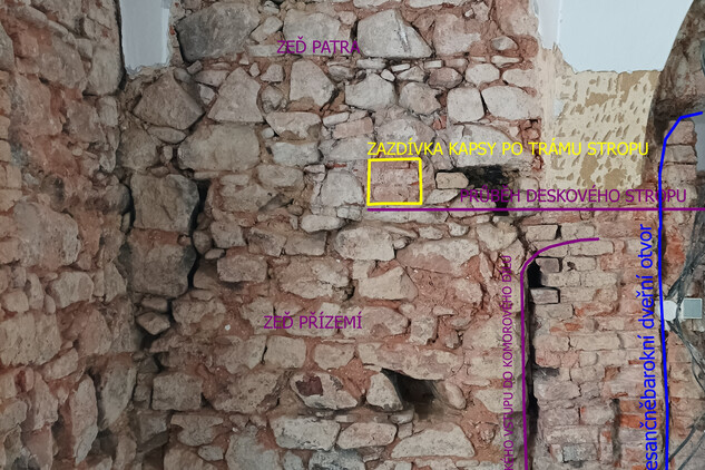 Místnost 004 – západní obvodová zeď místnosti zbavená omítek s patrnými nálezovými situacemi (přízemí a patro zděného komorového dílu středověkého domu s pozůstatky původního dřevěného trámového stropu a dveřního otvoru). Foto Petra Kaniová, NPÚ, ÚOP v Ostravě, 2022.