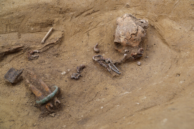 Hrob ženy z mladší doby železné (4.–5. století př. n. l.). Detail z hrobu. Patrný je bronzový náramek, železná jehlice, snad zbytek nákrčníku a další hrobové milodary (Fotoarchiv Archaia Brno).