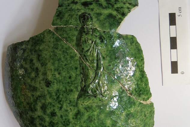 Zlomek džbánu se zelenou glazurou a reliéfní figurální výzdobou. Foto K. Matějková, CZ-DEAN, z.ú.