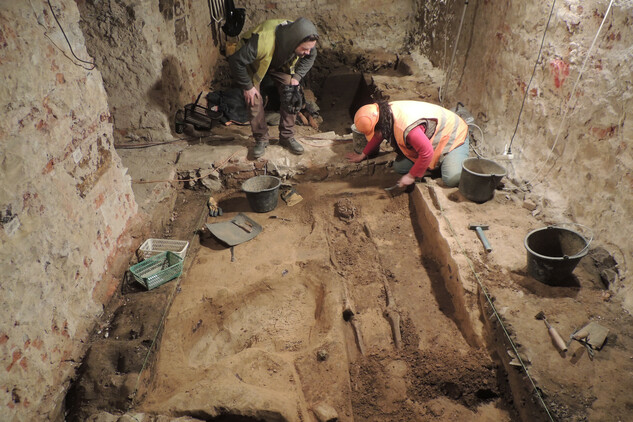 Odkrývání hrobu z 10. století objeveného pod podlahou sklepa jižního křídla Klementina v roce 2015