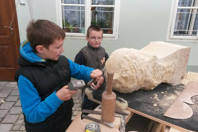 Žáci si zkoušejí práci kameníka.
