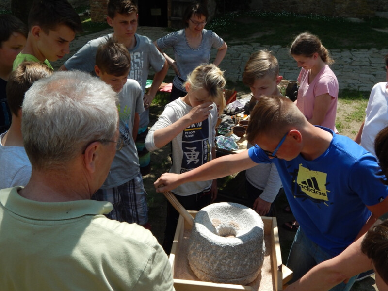 Edukační program na hradě Lipnice, mletí pšenice na kamenném mlýnku