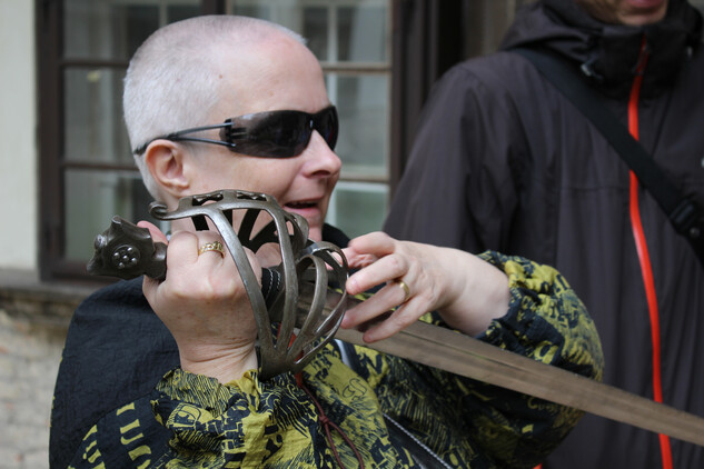 Nevidomá žena zkouší váhu zbraně